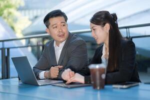 Business professionals working outdoors with laptop photo