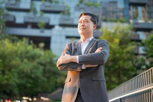 Young professional man in formal wear standing on the walkway outside a modern building photo