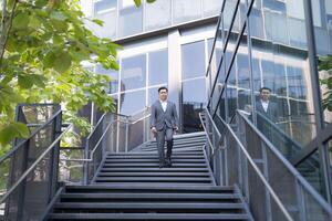 Professional male executive walking up stairs in an urban environment during the daytime photo
