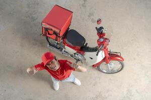 entrega hombre con motocicleta dando pulgar arriba foto