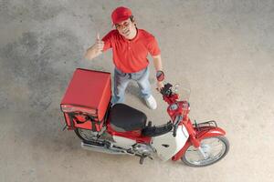 Delivery man with motorcycle giving thumb up photo