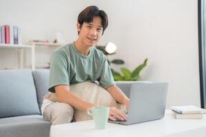 Thoughtful man using laptop at home photo