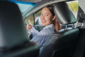 Confident young woman driving car photo