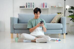 Young man enjoying smartphone in a modern living room photo