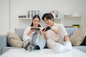 Excited young couple playing smartphone games on couch photo