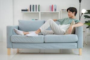 Young man relaxing on sofa in modern living room photo