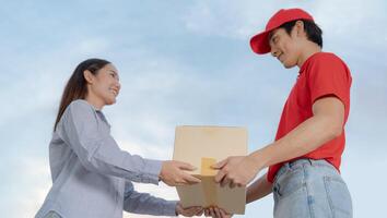 Courteous delivery guy handing over package to female customer photo