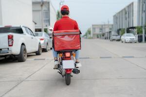 Delivery rider on motorbike in urban setting photo