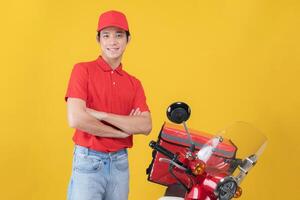 Confident delivery man with motorcycle on yellow background photo