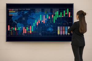 Businesswoman analyzing stock market data on digital screen photo