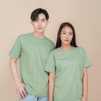 Young couple in casual green t-shirts posing together photo