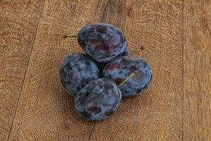 Ripe plum heap over background photo