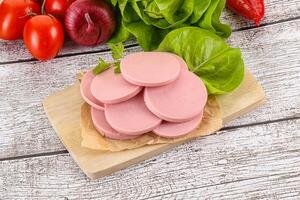 Slices boiled sausages for breakfast photo