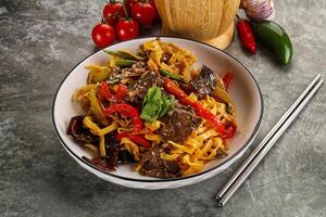 Asian wok with noodle, vegetables and beef photo