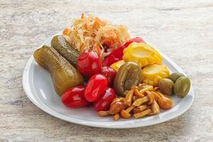 Plate with pickled vegetables and mushrooms photo