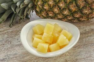 Marinated pineapple slices in the bowl photo