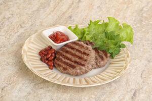 Grilled beef burger cutlet with sauce photo