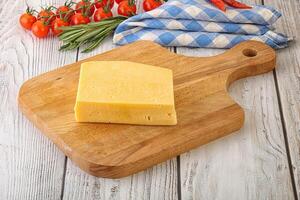 Piece of natural organic cheese over board photo