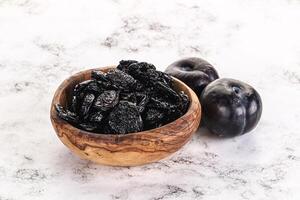 Dry prunes in thw bowl photo