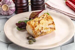 Roasted cod fish steak with salad photo