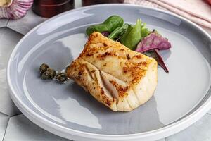 Roasted cod fish steak with salad photo