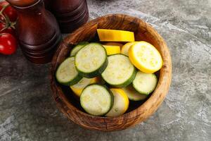 Sliced raw young green and yellow zucchini photo