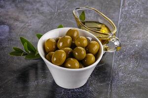 Ripe tasty green olives with branch photo