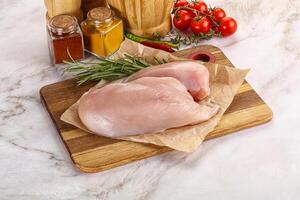 Raw chicken breast served rosemary photo