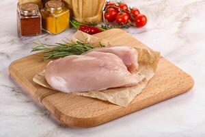 Raw chicken breast served rosemary photo