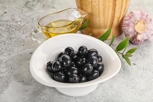 Black olives with oil and branch photo