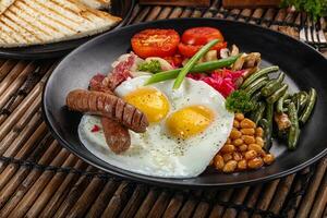 Traditional Engrlish breakfast with egg and sausages photo