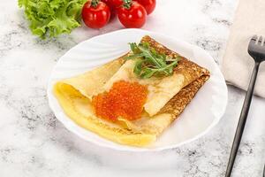 Russian pancake with red caviar photo