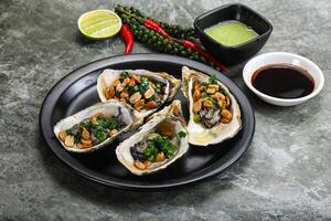 Open half oysters with green onion photo