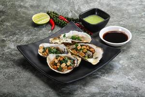 Open half oysters with green onion photo