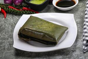 Asian cuisine - rice with filling in banana leaf photo