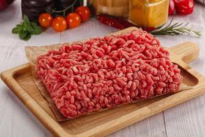 Raw minced beef meat over board photo