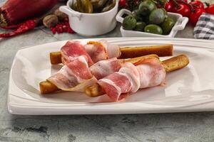 Antipasti - Grissini with pork bacon photo