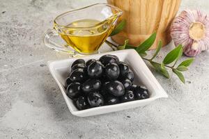 Black olives with oil and branch photo