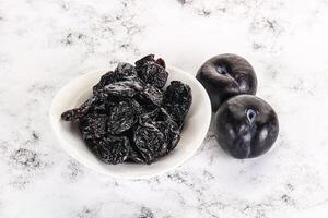 Dry prunes in thw bowl photo