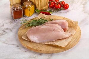 Raw chicken breast served rosemary photo