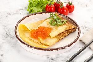 Russian pancake with red caviar photo