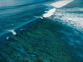 Aerial view with surfing on wave. Perfect waves with surfers in clear ocean photo