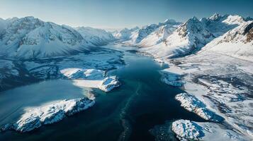 Snowcapped mountains embrace a river in a winter wonderland from above photo