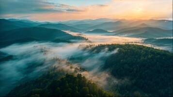 Sunset illuminating fog over mountain range viewed from above photo