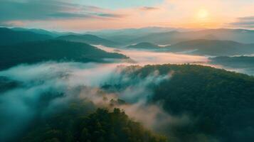 An aerial view of misty mountains at dusk with water, clouds, and dramatic sky photo