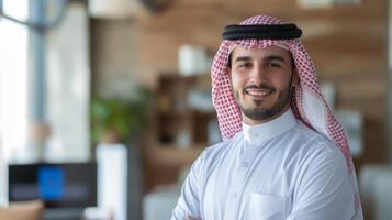 Confident Middle Eastern Businessman in Traditional Attire Smiling in Modern Office Setting photo