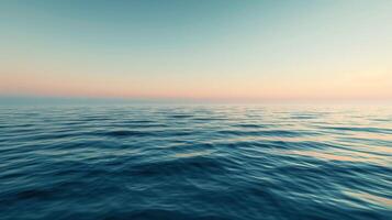 Blurry sunset sky reflected on fluid surface of large body of water photo