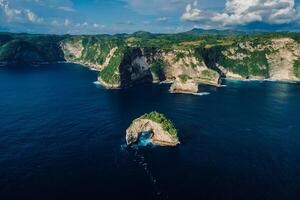 Coastline with rocky cliffs and ocean in Nusa Penida. Aerial view of island photo