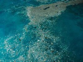 Indian ocean and plastic trash, drone view. Pollution by plastic rubbish in Bali photo