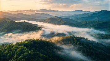 Misty mountains seen from above as the sun sets behind the clouds photo